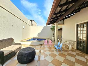 a patio with a table and chairs and a swimming pool at No Centro 9 pessoas com Piscina e Churrasqueira in Foz do Iguaçu