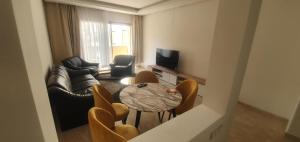 a living room with a couch and a table and chairs at Taj linving in Nouaceur