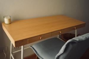 a wooden table with a candle and a chair at La Suite del Maestro in Bienno