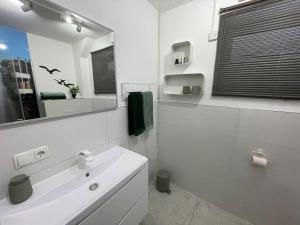 a white bathroom with a sink and a mirror at Ferienwohnung-neu renoviert-nahe Regensburg in Bad Abbach