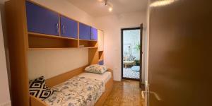 a small bedroom with a bed and blue cabinets at Apartments Stella in Piran