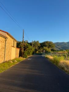 an empty road with a building and mountains in the background at La bodeguita 1 in Saint-Génis +5 photos