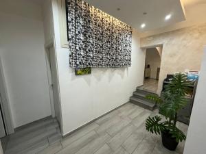 a hallway with a white wall with a plant at Meghan Home in Catania