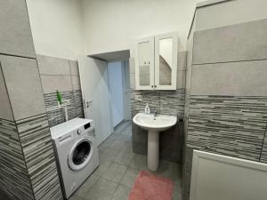 a bathroom with a washing machine and a sink at Meghan Home in Catania