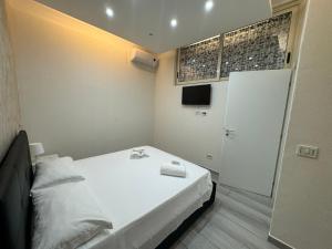 a small bedroom with a white bed and a door at Meghan Home in Catania
