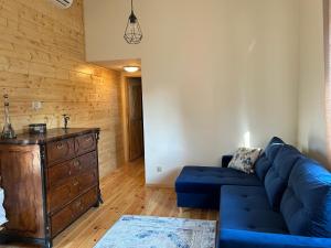 ein Wohnzimmer mit einem blauen Sofa und einer Holzwand in der Unterkunft Sielsko Anielsko in Grodzisk + 3 Fotos