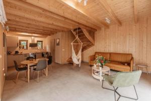 a living room with wooden ceilings and a table and chairs at Chaty Jagi Domek 2 in Czorsztyn