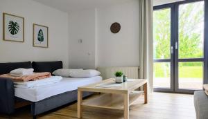 a living room with a bed and a table at Domki na Wodnej in Kołobrzeg
