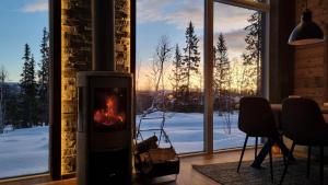a fireplace in a room with a view of the snow at Fjellyx i funäs med relax&bastu, badtunna, 13 bädd in Funäsdalen