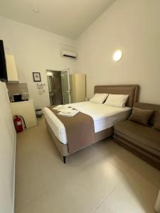 a bedroom with a large bed and a couch at Sun's Suites in Asprovalta