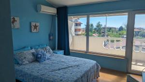 a bedroom with a bed and a large window at Guest House Chalakov in Sinemorets