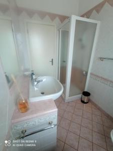 a white bathroom with a sink and a shower at Casa Vintago b&b in Savio di Ravenna