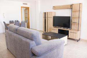 a living room with a couch and a television at Apartamentos Sol de Águilas in Águilas +92 photos