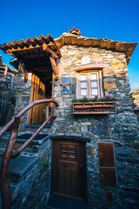 un edificio de piedra con una ventana y una puerta en Montanhas do Xisto - Casa do Portal, en Lousã