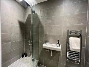a bathroom with a shower and a sink at The Card Room at Ryedale House in York