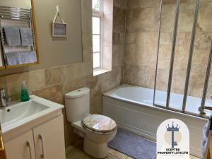 ein Badezimmer mit Badewanne, Toilette und Waschbecken in der Unterkunft Beautiful Self-contained Cottage in Ickenham