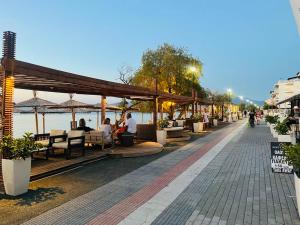 a street with people sitting at tables and umbrellas at Irene Beach Front Luxury Suite in Perea