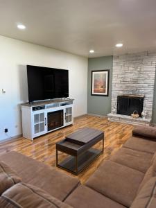 a living room with a flat screen tv and a fireplace at Rancho Alegre Country Retreat in Pueblo