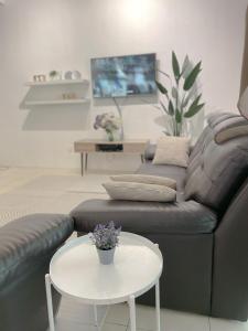 a living room with a couch and a table at Zara Cozy Homestay in Seri Iskandar