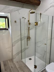 una ducha con puerta de cristal en un baño en Boutique Vila de Triacastela, en Triacastela 31 fotos más
