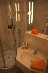 a bathroom with a sink and a shower and a tub at Feriendomizil am Kurplatz in Norderney