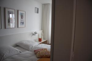 ein Schlafzimmer mit einem Bett mit zwei Kissen darauf in der Unterkunft Feriendomizil am Kurplatz in Norderney