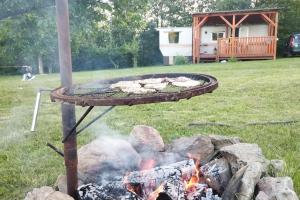 a fire pit with food on it in a yard at Mobilheim Dědova zahrada in Jevišovice