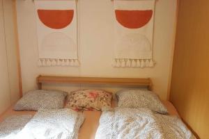a small bedroom with two pillows and two windows at Mobilheim Dědova zahrada in Jevišovice