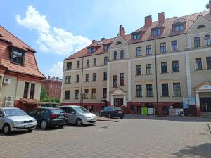 a group of cars parked in front of buildings at Lemuria Pokoje Hostel Chojnowska A in Legnica