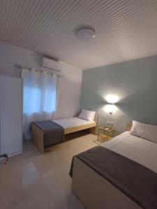 a hotel room with two beds and a window at Angie's House Sykia in Sikia