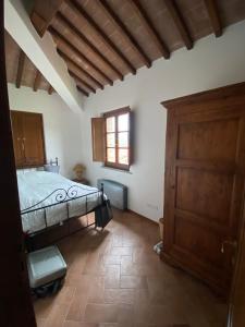 una camera da letto con un letto e una porta di legno di House in Tuscany - Casa La Scala a Gaiole in Chianti