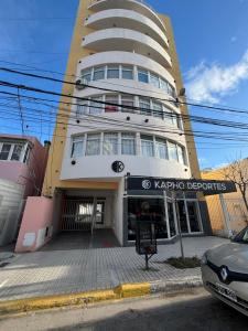 a building with a parking garage in front of it at Maison Rouge Puerto Madryn in Puerto Madryn