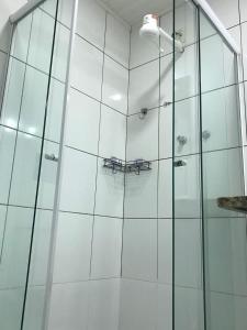 a shower with a glass door with a table in it at Brothers Suites Centro Búzios in Búzios