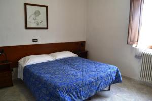 リヴォルノにあるAlbergo Imperialeのベッドルーム1室(青い毛布付きのベッド1台付)
