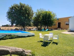a yard with a table and chairs next to a pool at Casa rural Cerro Campón in Carmona