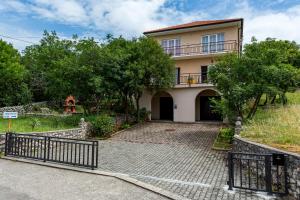 a house with a gate in front of a driveway at Apartments Claudia in Šmrika