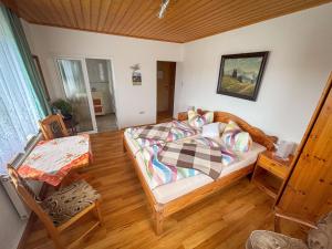 a bedroom with a bed and a table in it at Bergheisl Rübenau in Rübenau