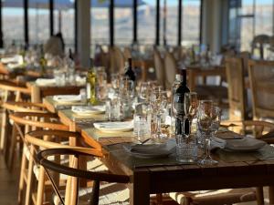 a long wooden table with glasses and a bottle of wine at Thabeng Hotel & Restaurant in Maseru
