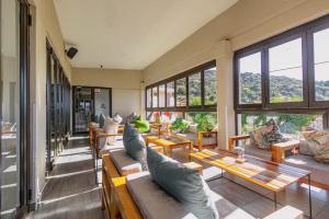 a living room with couches and tables and windows at Thabeng Hotel & Restaurant in Maseru