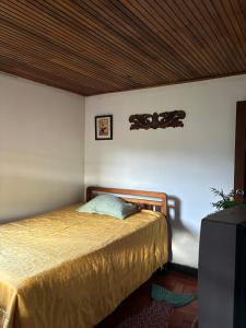 una camera da letto con un letto con soffitto in legno di Hostal antaño a Duitama
