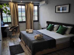 a bedroom with a large bed with green pillows at The Hill in Veliko Tŭrnovo