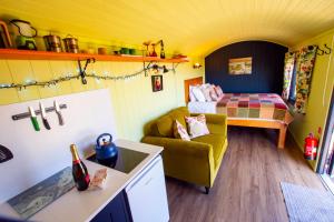 a small room with a bed and a couch at The Gambo Shepherd's Hut in Kidwelly