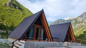 a cabin in the mountains with mountains in the background at Bungaja Chalets in Shkodër