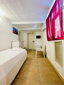 Un dormitorio con una cama y una silla y una ventana. en Catania Vibes, en Catania 127 fotos más