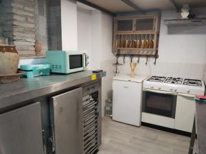 a kitchen with a microwave and a stove at Casa rural Cerro Campón in Carmona