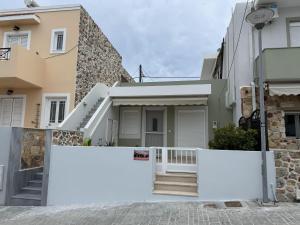 a house with a white fence in front of it at Holiday Dream Thalia Apartment in Mastichari +10 photos