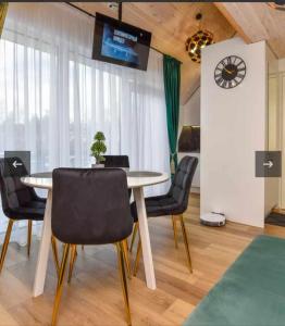 a dining room with a table and chairs and a clock at Čiki puki loftas in Palanga