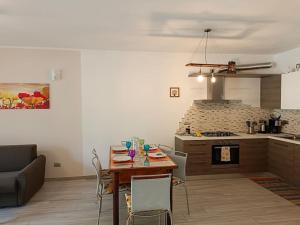 杜比诺Tra lago e montagne home nonna Maria的客厅里有一张桌子和一个厨房