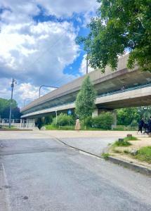 a woman walking down a street next to a bridge at Studio ESKIA in Bry-sur-Marne +2 photos
