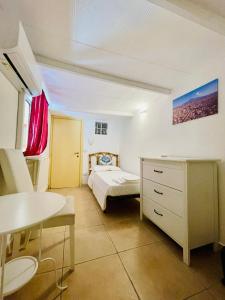 Un dormitorio con una cama, un escritorio y una mesa. en Catania Vibes, en Catania